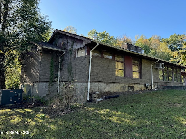 view of side of property featuring a yard, cooling unit, and a wall unit AC