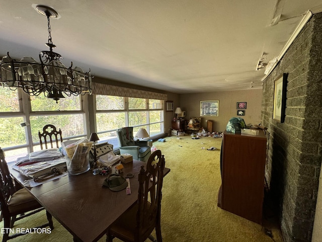 carpeted dining area featuring an inviting chandelier and brick wall