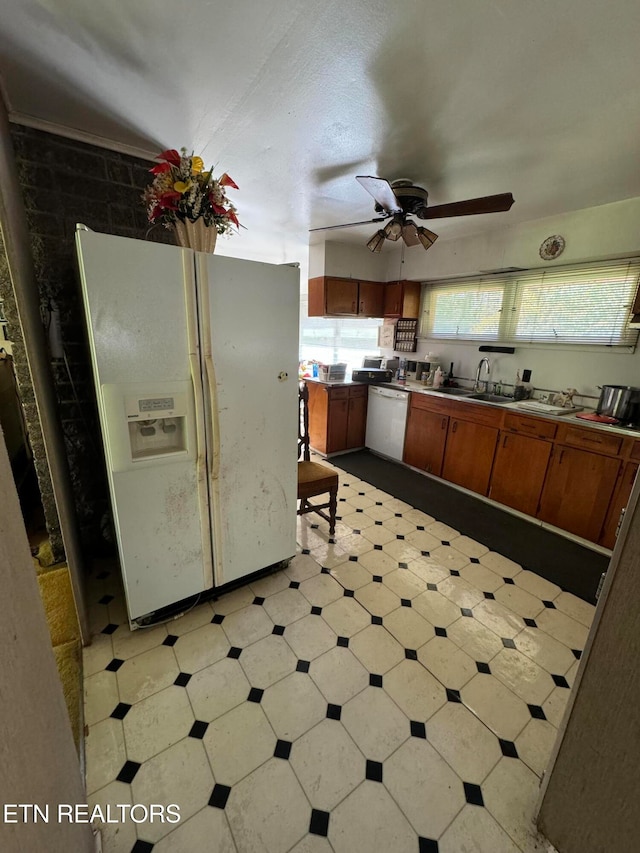 kitchen with white appliances, ceiling fan, and sink