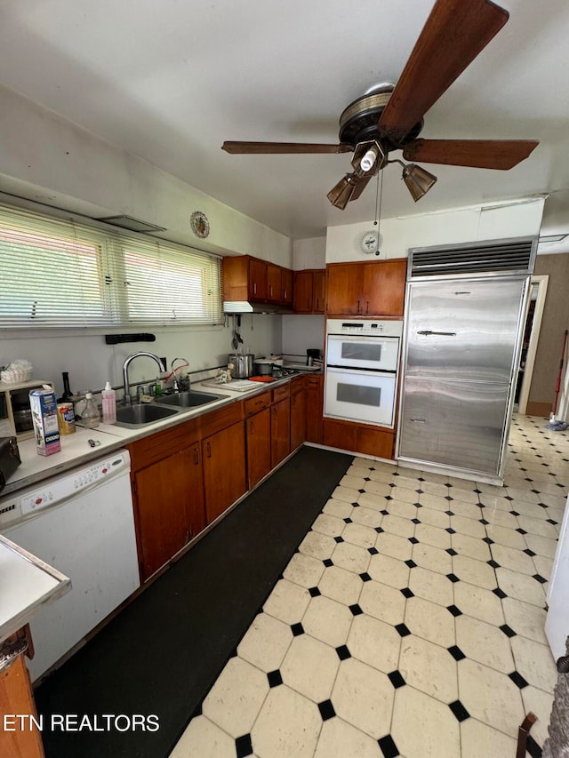 kitchen with ceiling fan, sink, white appliances, and a healthy amount of sunlight