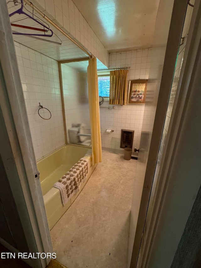 bathroom with tile walls and shower / bath combo