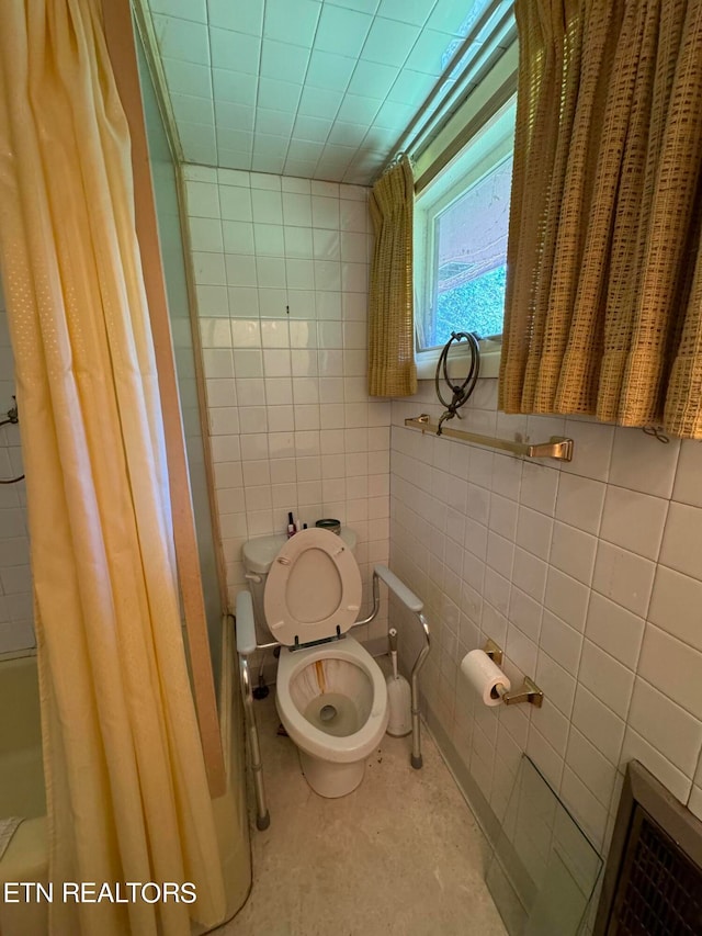 bathroom with tile walls, toilet, and shower / bath combo