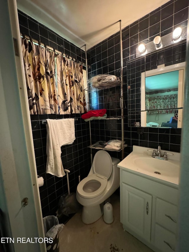 bathroom with vanity, tile walls, and toilet