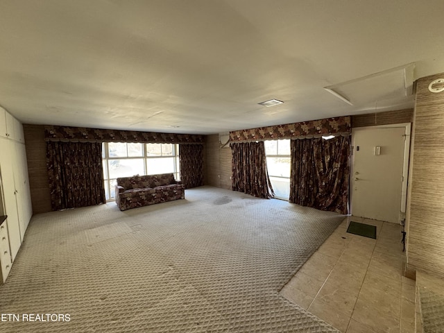 unfurnished living room with carpet floors and a healthy amount of sunlight