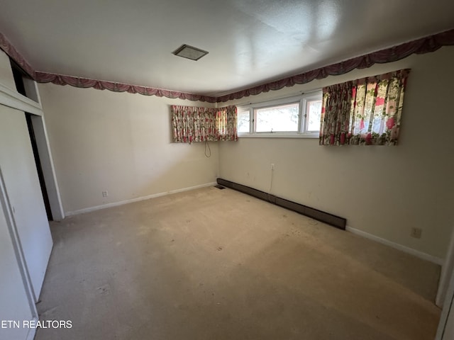 unfurnished bedroom featuring baseboard heating and a closet