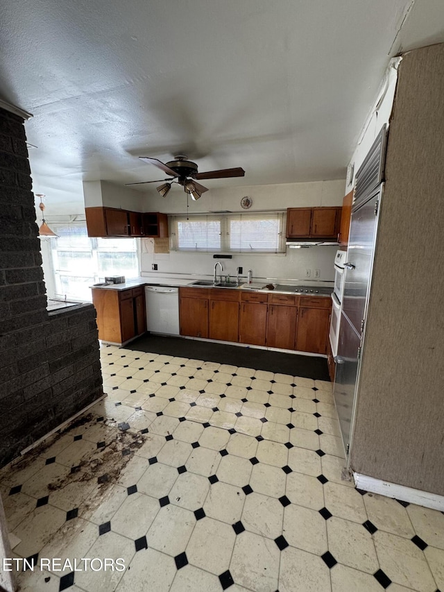 kitchen featuring white dishwasher, sink, kitchen peninsula, and ceiling fan