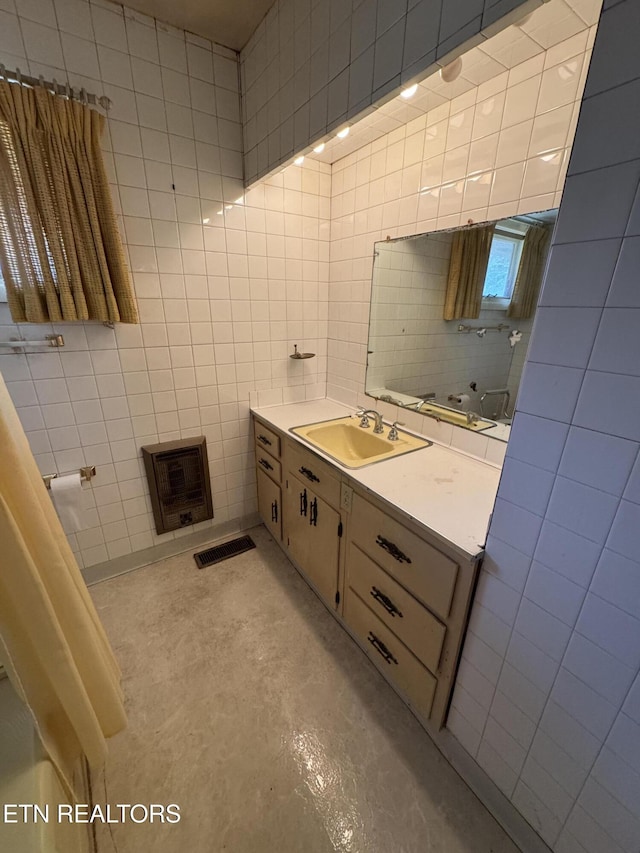 bathroom featuring tile walls, vanity, and concrete floors