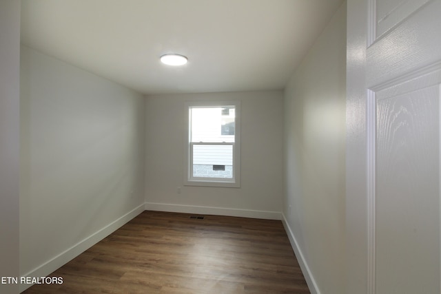 unfurnished room featuring dark wood-type flooring