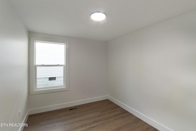 unfurnished room with hardwood / wood-style flooring