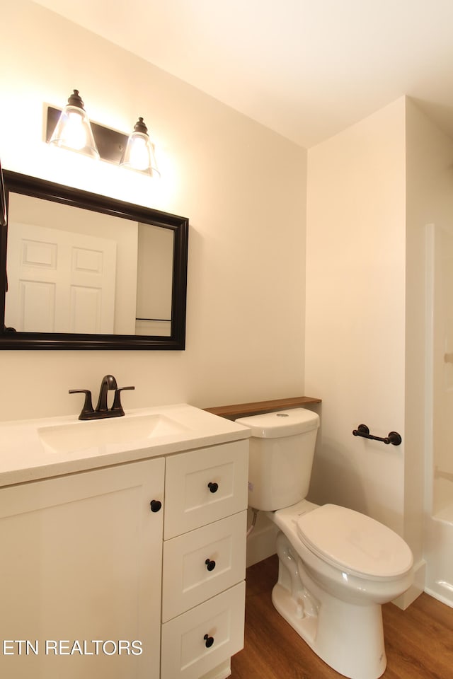 full bathroom with toilet, vanity, hardwood / wood-style floors, and plus walk in shower