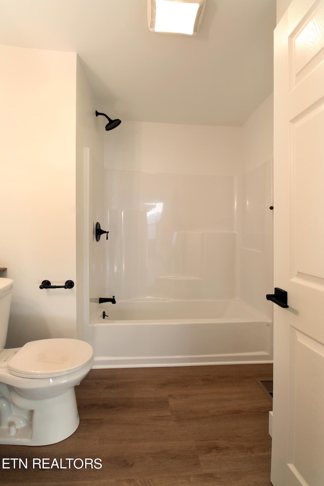 bathroom featuring shower / tub combination, toilet, and wood-type flooring