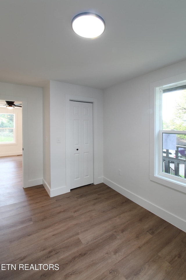 unfurnished bedroom with a closet and dark hardwood / wood-style flooring