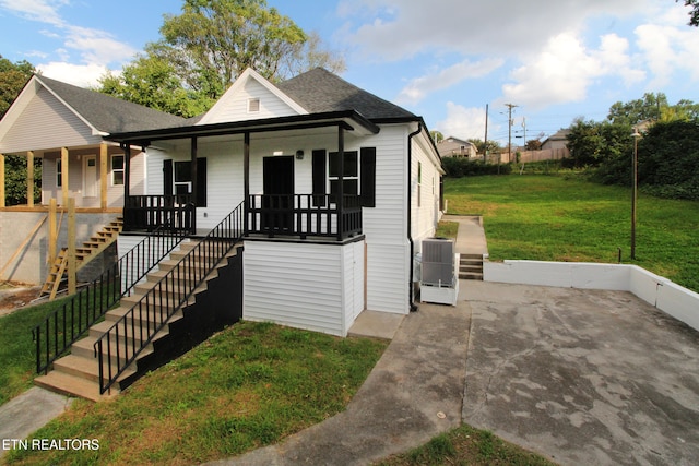 bungalow-style home with central AC, covered porch, and a front yard