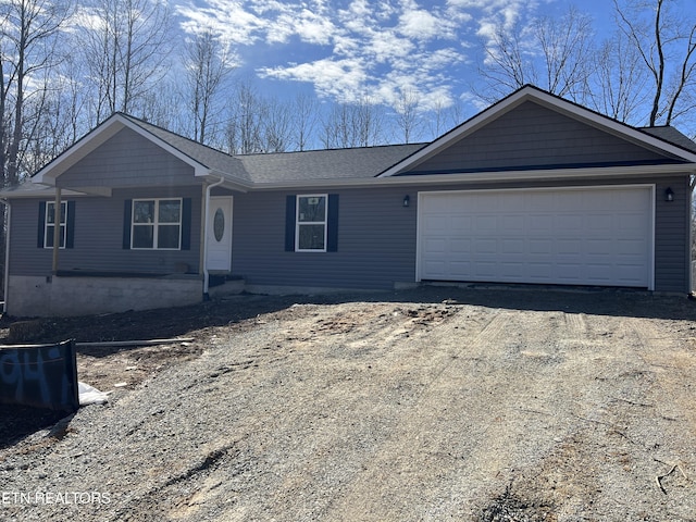 ranch-style home with an attached garage and dirt driveway