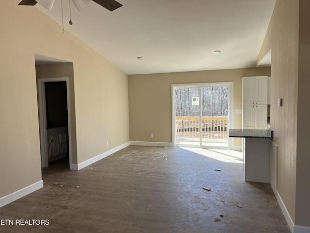 empty room featuring baseboards and vaulted ceiling