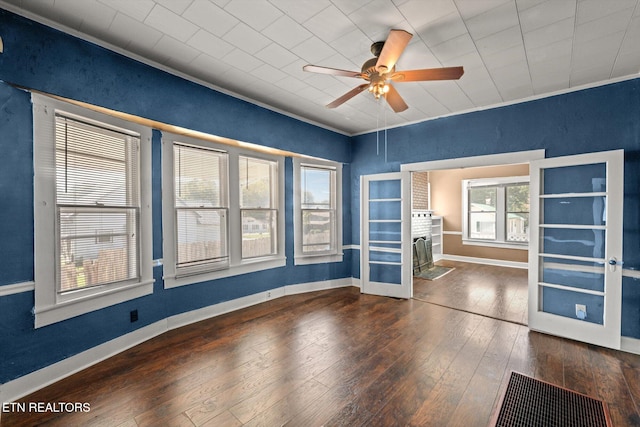 unfurnished room featuring ornamental molding, ceiling fan, dark wood-type flooring, and french doors