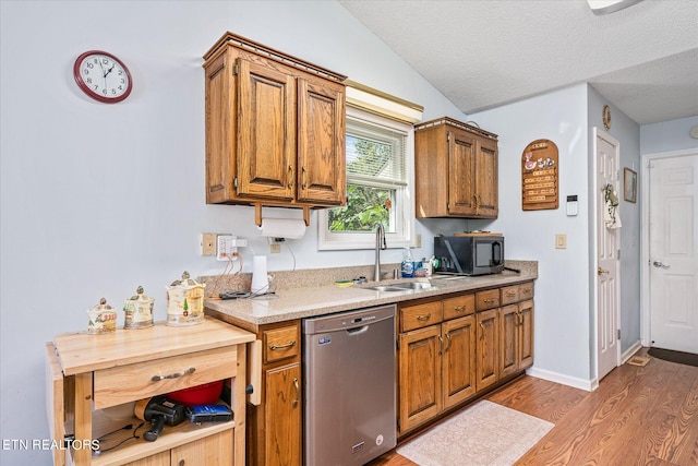 kitchen with lofted ceiling, sink, a textured ceiling, dishwasher, and light hardwood / wood-style floors