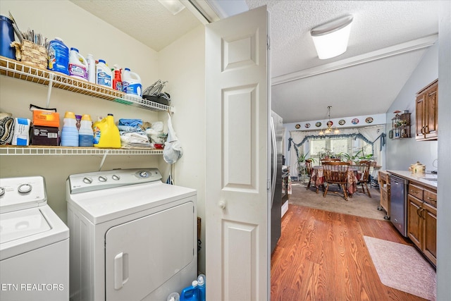 washroom with independent washer and dryer, wood-type flooring, and a textured ceiling