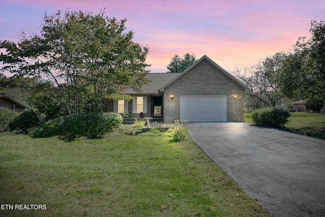 view of front of house with a garage and a lawn