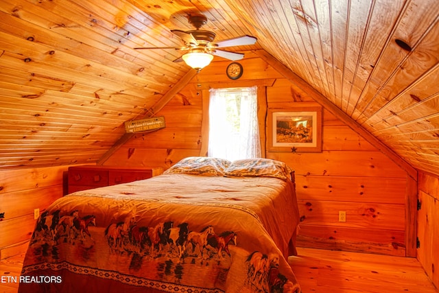 bedroom featuring lofted ceiling, wood ceiling, light hardwood / wood-style flooring, and wooden walls