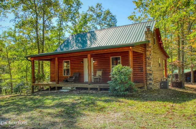 log cabin featuring central AC and a front lawn