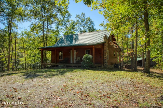 log-style house with a front yard and covered porch