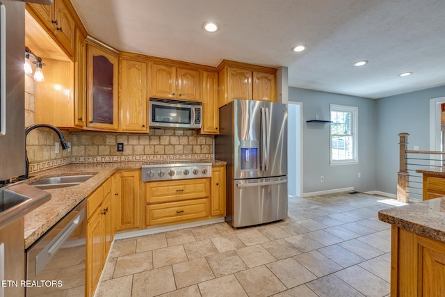 kitchen with sink, stainless steel appliances, and tasteful backsplash