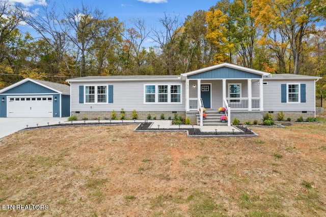 view of front of home with an outbuilding, a porch, a garage, and a front lawn