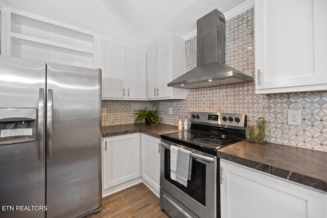 kitchen with white cabinets, wall chimney exhaust hood, appliances with stainless steel finishes, dark hardwood / wood-style flooring, and decorative backsplash