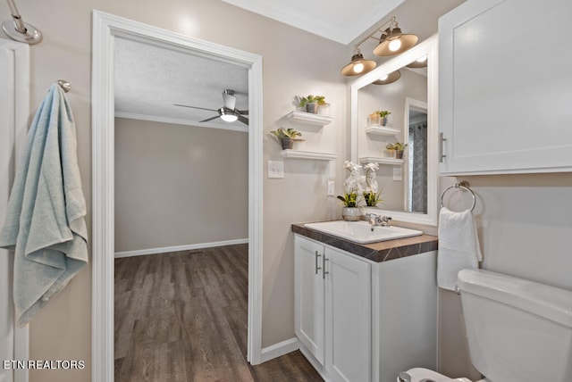 bathroom with vanity, hardwood / wood-style floors, toilet, and crown molding