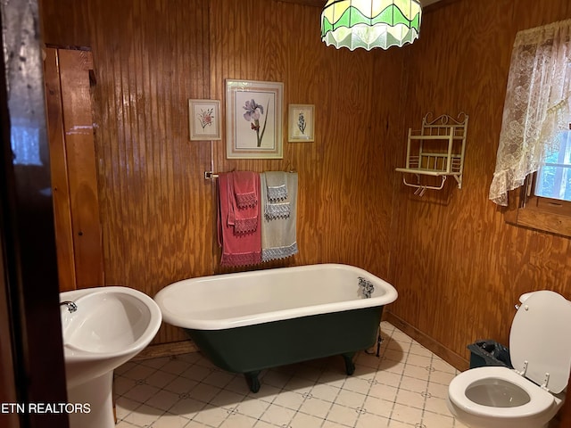 bathroom featuring wood walls, toilet, and a tub