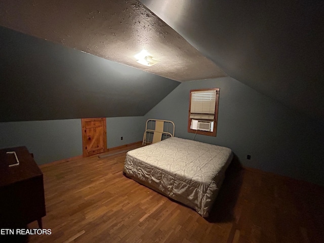 bedroom featuring cooling unit, lofted ceiling, and hardwood / wood-style flooring