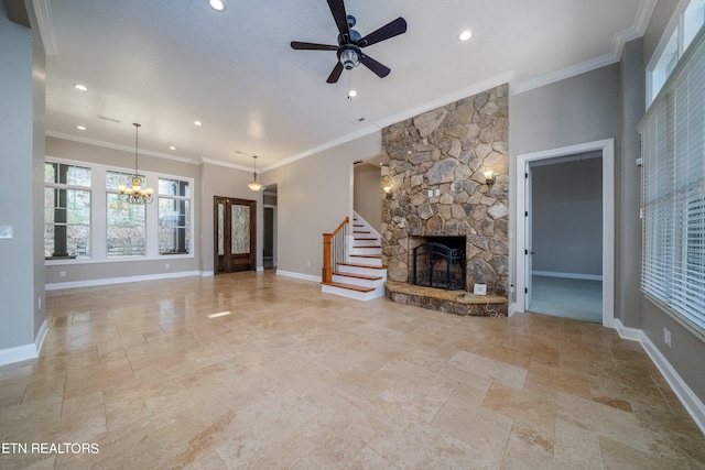 unfurnished living room with ceiling fan with notable chandelier, a fireplace, and ornamental molding