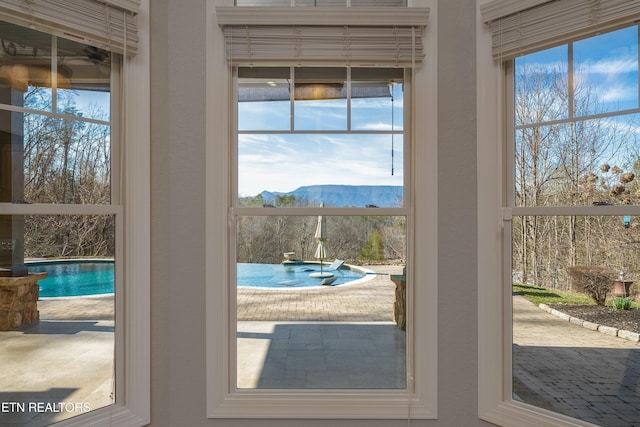 entryway featuring ceiling fan, a mountain view, and a healthy amount of sunlight