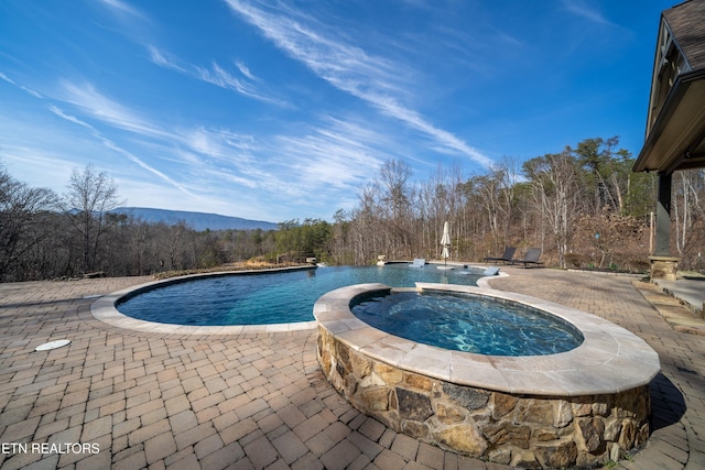 view of swimming pool with a mountain view, a patio, an in ground hot tub, and pool water feature