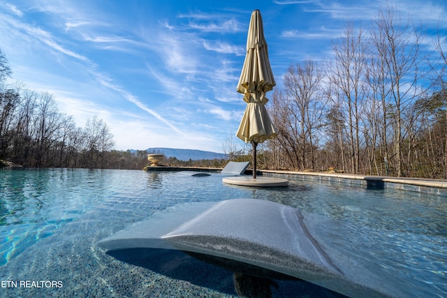 view of pool featuring a water view