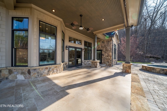 view of patio with ceiling fan and an in ground hot tub