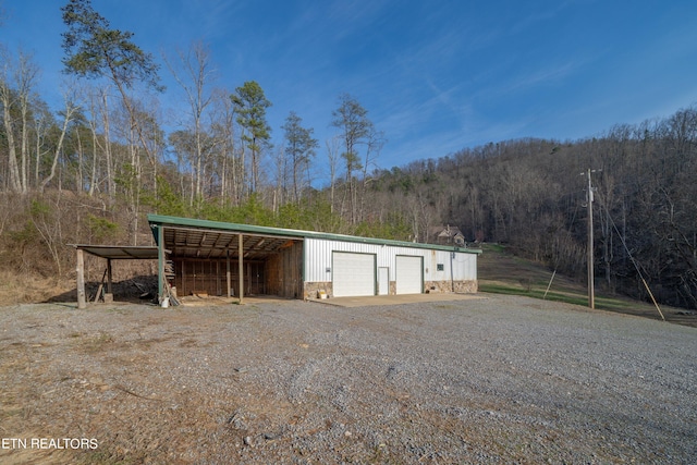 view of outdoor structure with a carport and a garage