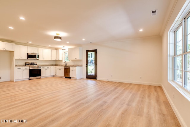 kitchen with white cabinets, stainless steel appliances, and a wealth of natural light