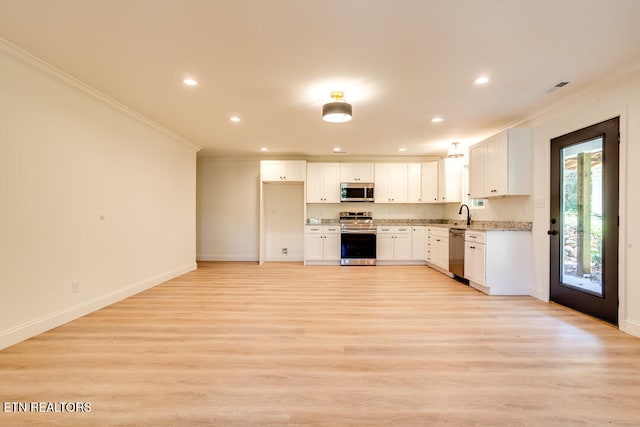 kitchen with light hardwood / wood-style flooring, stainless steel appliances, ornamental molding, and white cabinetry