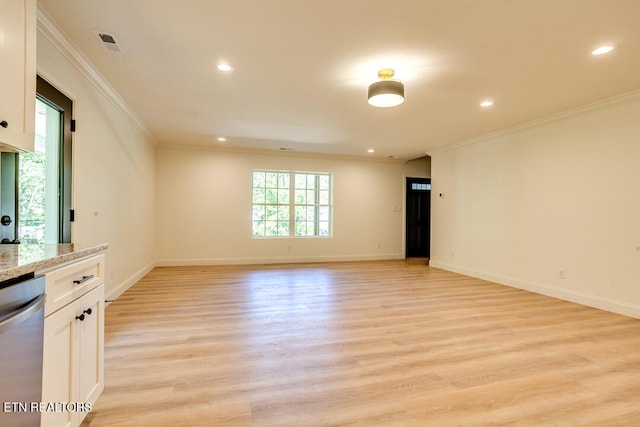 spare room featuring crown molding and light hardwood / wood-style floors