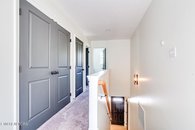 hallway featuring light colored carpet