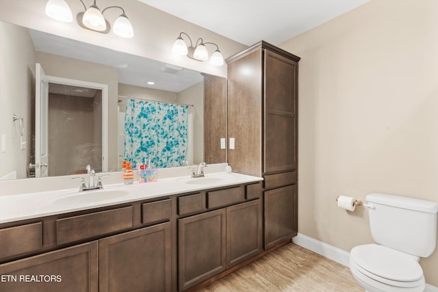 bathroom with curtained shower, wood-type flooring, vanity, and toilet