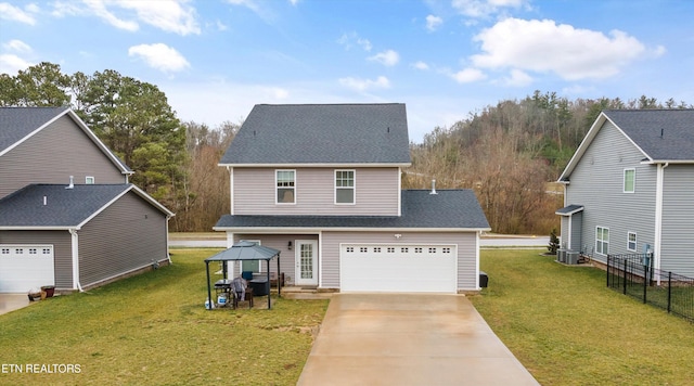 view of front of home featuring a front lawn, central air condition unit, and a garage