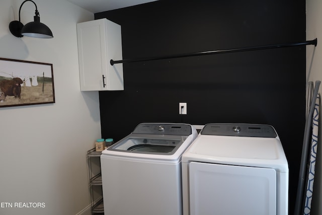 washroom featuring washer and clothes dryer and cabinets