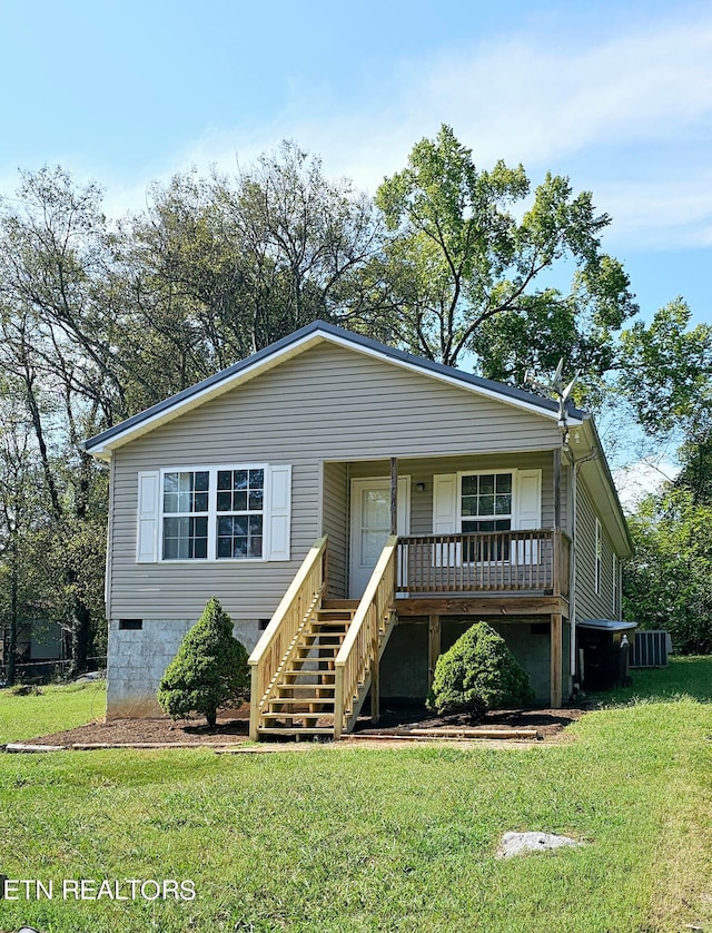 view of front of house with a front yard and central air condition unit