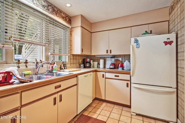 kitchen with a textured ceiling, sink, backsplash, white appliances, and light tile patterned floors