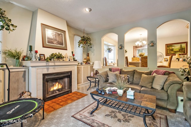 carpeted living room featuring a textured ceiling and a tile fireplace