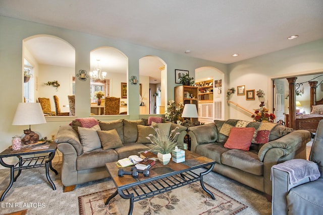 carpeted living room featuring an inviting chandelier, arched walkways, and recessed lighting