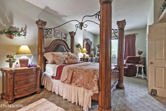 bedroom with a textured ceiling and dark colored carpet